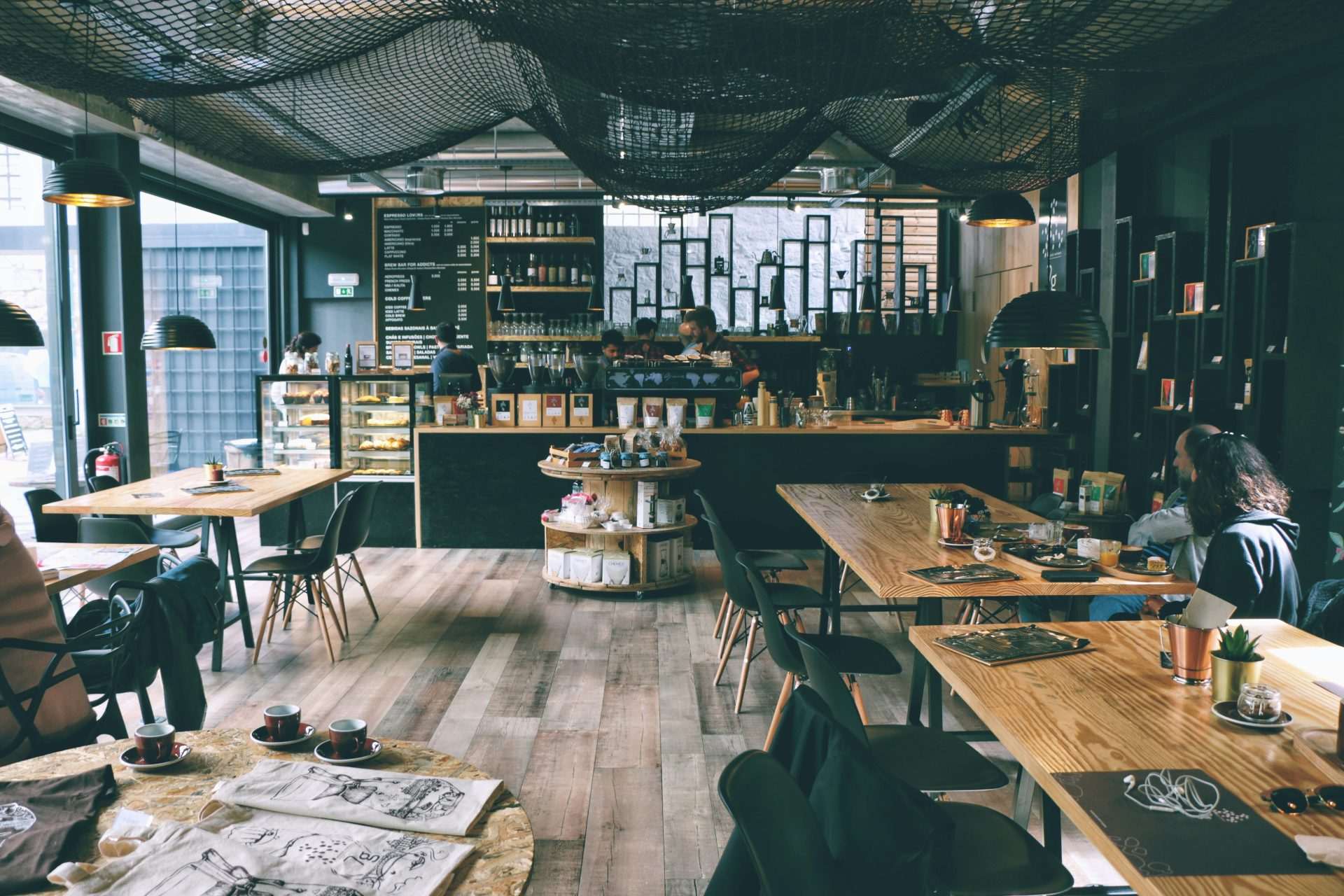 Café mit Gästen, Theke und Holztischen